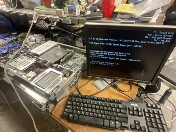 Dell server open on workbench with POST screen showing successful boot