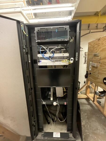 Equipment Room — full rack with switches, fiber panels, and backbone terminations